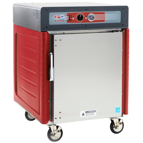 A red and silver Metro insulated hot holding cabinet with wheels.