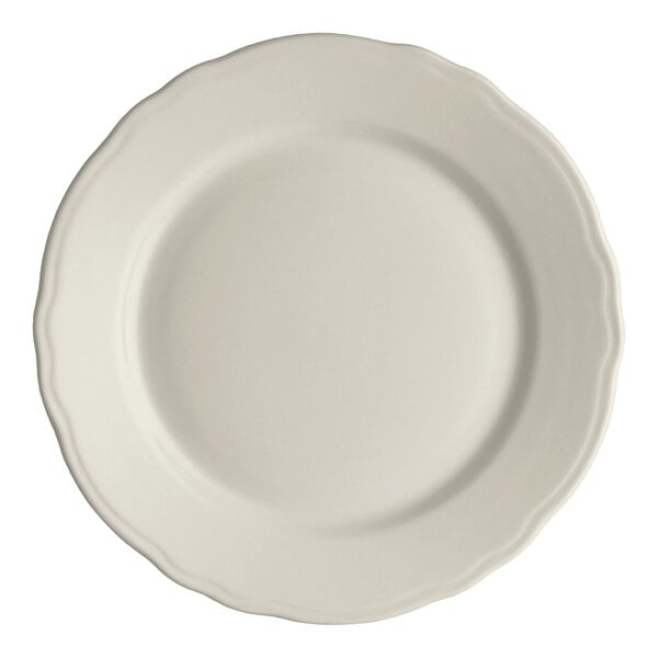 An ivory-colored, round plate with a scalloped edge.
