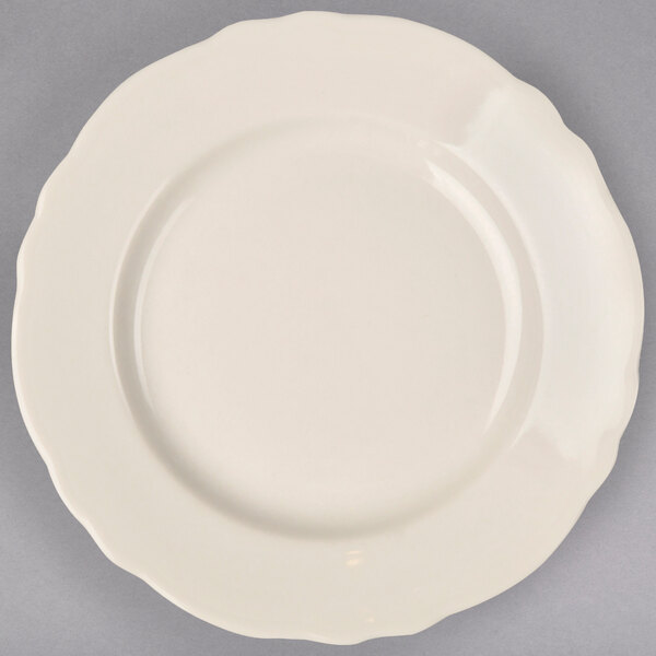 A Homer Laughlin ivory scalloped edge plate with a white circular edge.
