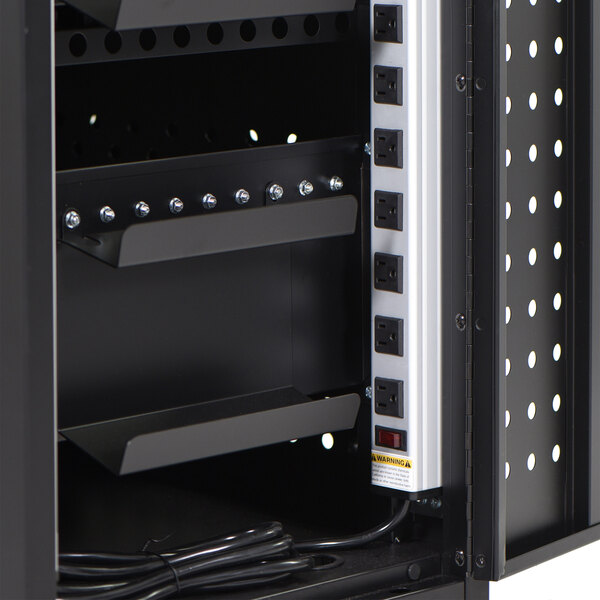 A black metal Luxor tablet charging station with a power outlet.