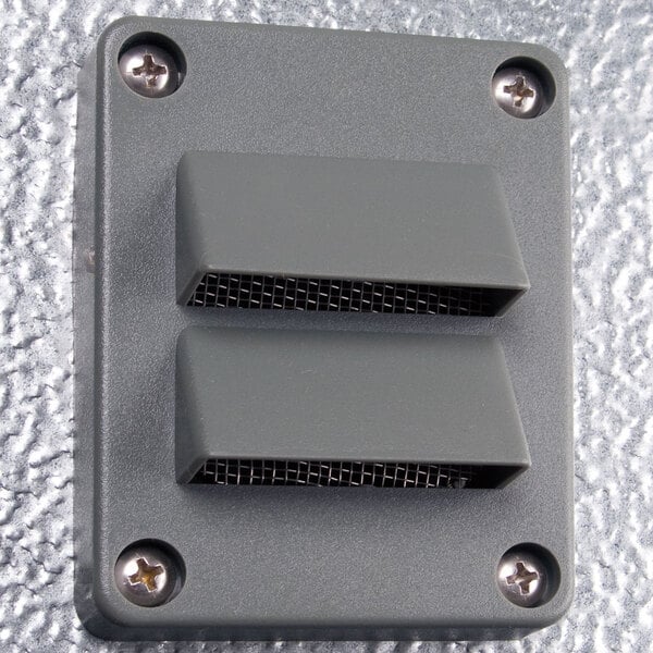 A grey rectangular metal wall plate with two holes.