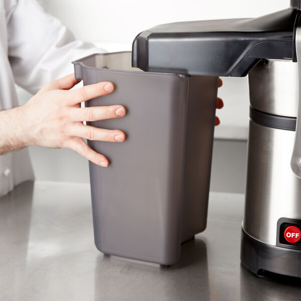 A person holding a grey plastic pulp collector.
