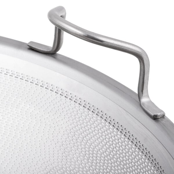 A stainless steel filter basket assembly for a juicer with a metal pan handle.