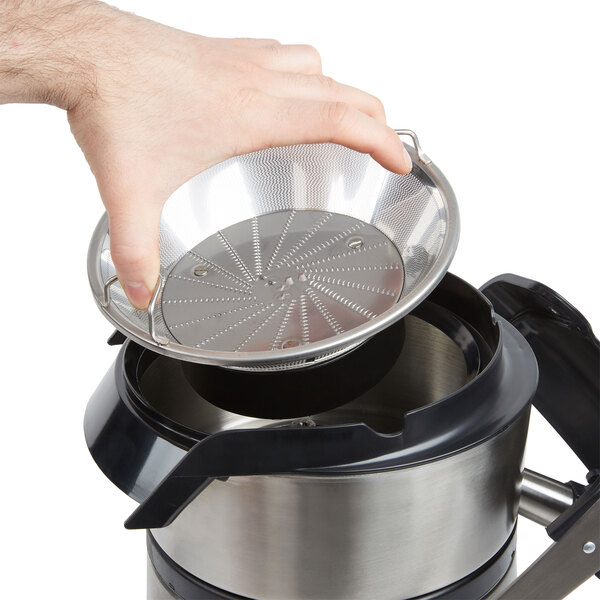 A hand holding a stainless steel AvaMix filter basket.