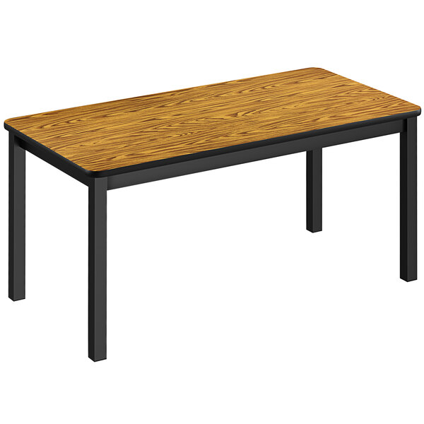 A medium oak Correll library table with black legs.