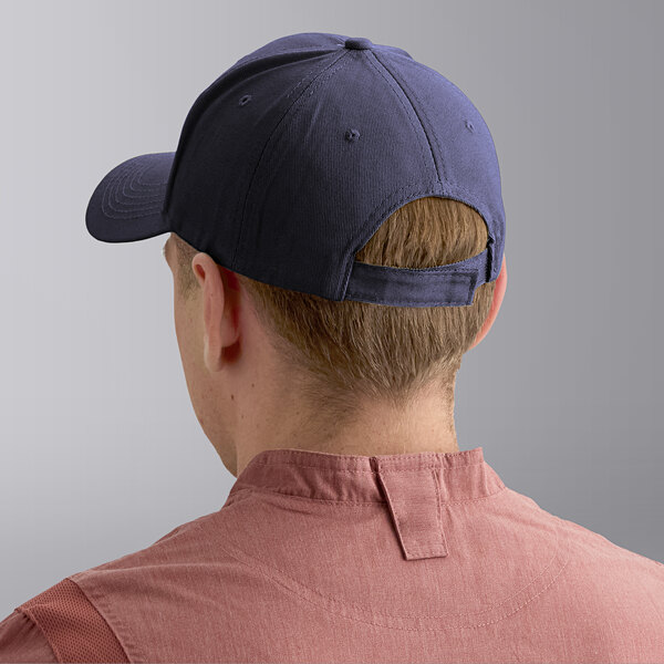 A navy blue 6-panel cap with an adjustable strap at the back, shown on a person wearing a red shirt.