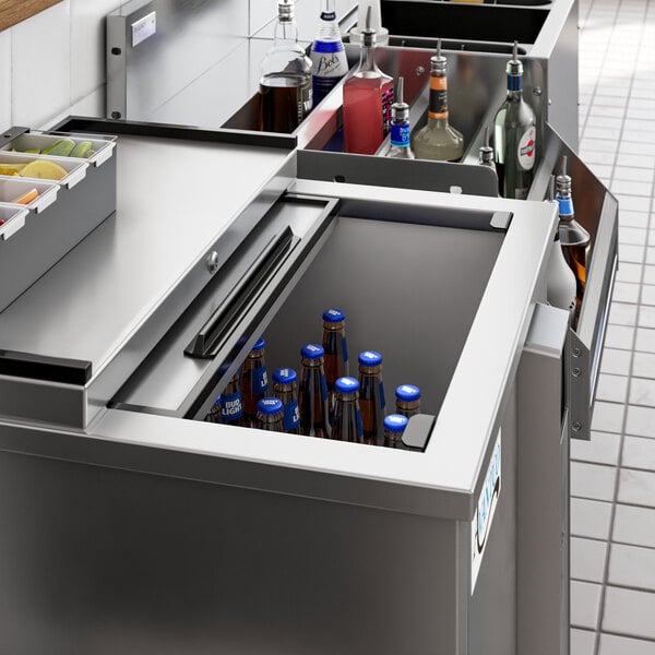 An Avantco stainless steel horizontal bottle cooler on a counter with bottles inside.