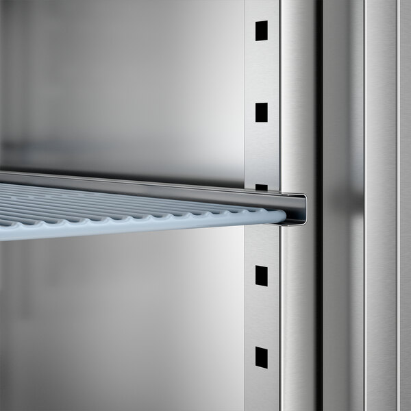 A stainless steel reach-in freezer with adjustable shelving.