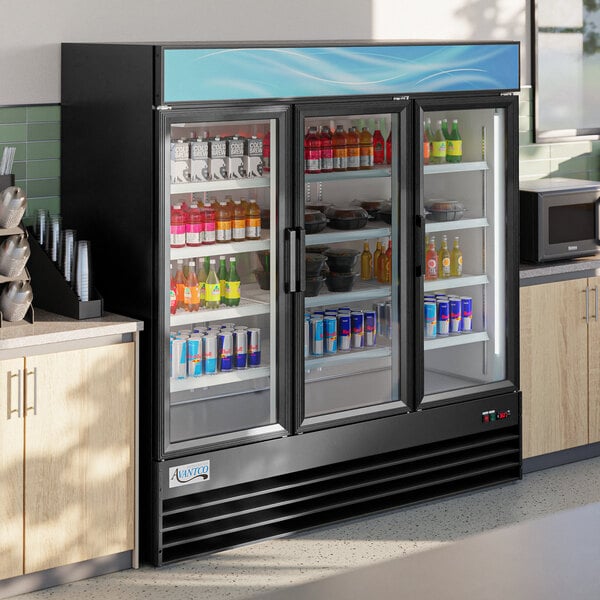 An Avantco black customizable swing glass door merchandiser refrigerator with drinks inside.