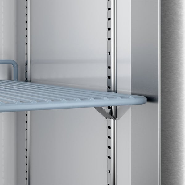 A metal wire shelf inside a stainless steel reach-in freezer.