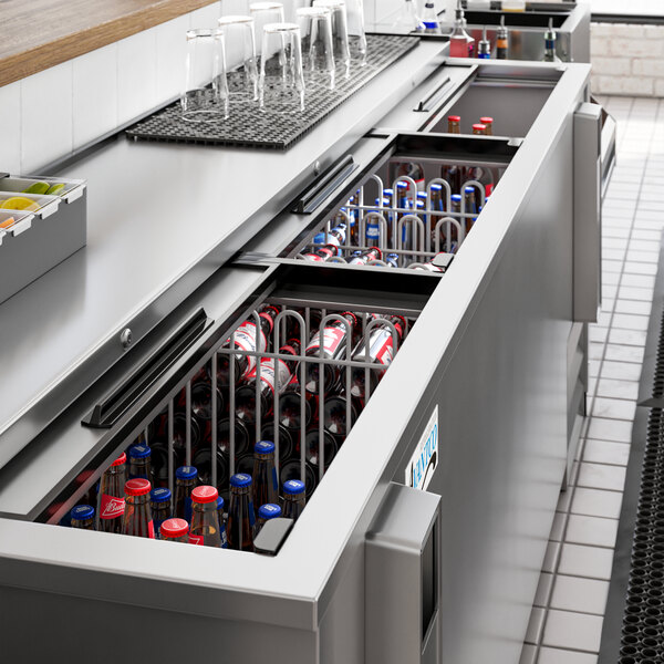 An Avantco stainless steel horizontal bottle cooler on a counter with bottles inside.
