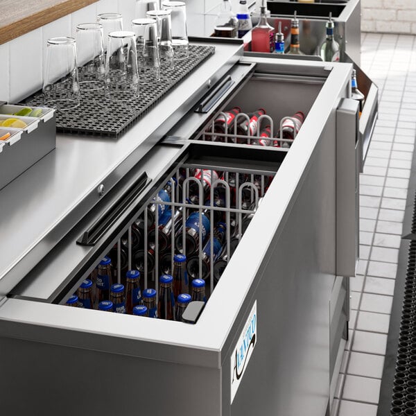 An Avantco stainless steel horizontal bottle cooler on a counter with bottles inside.