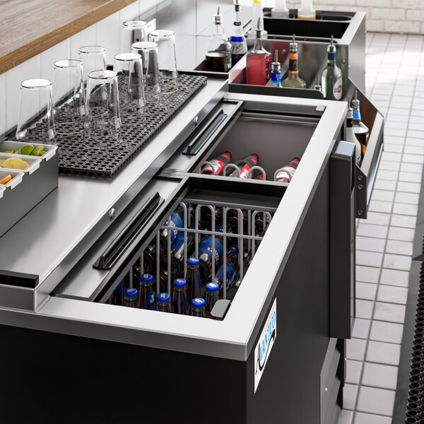 An Avantco black horizontal bottle cooler on a counter with drinks inside.