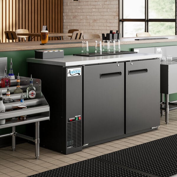 An Avantco black counter height back bar refrigerator with bottles on a shelf
