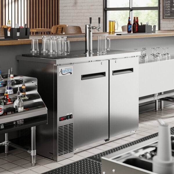 An Avantco stainless steel kegerator with two taps on a counter.