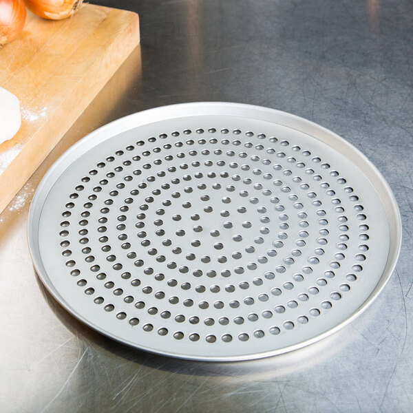 A circular metal pizza pan with holes in it.