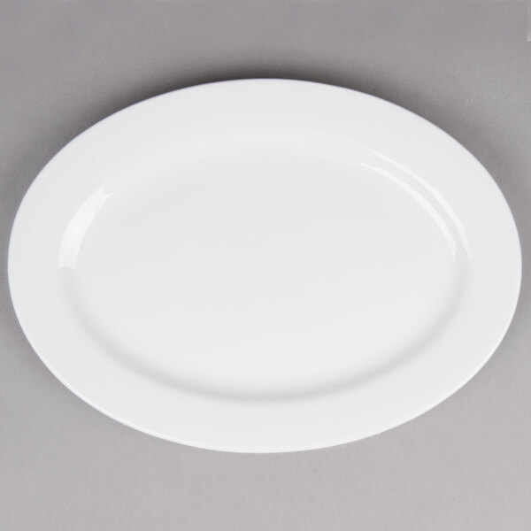 A Tuxton bright white china oval platter on a gray surface.