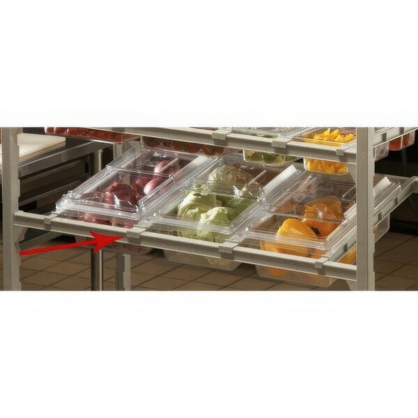 A shelf with plastic containers of vegetables in a Cambro Camshelving® rack with an Angled Divider Bar.