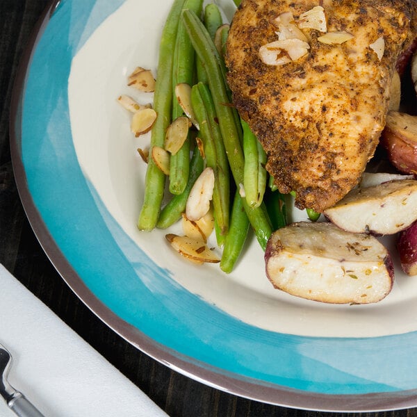 A Kanello Diamond Ivory melamine plate with a chicken breast and potatoes with a fork and knife.