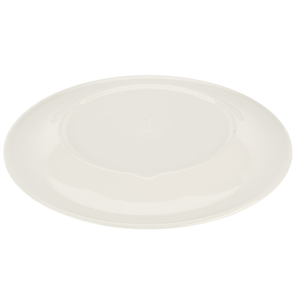 A white plate with a small circular diamond design on the rim and a Kanello green edge.