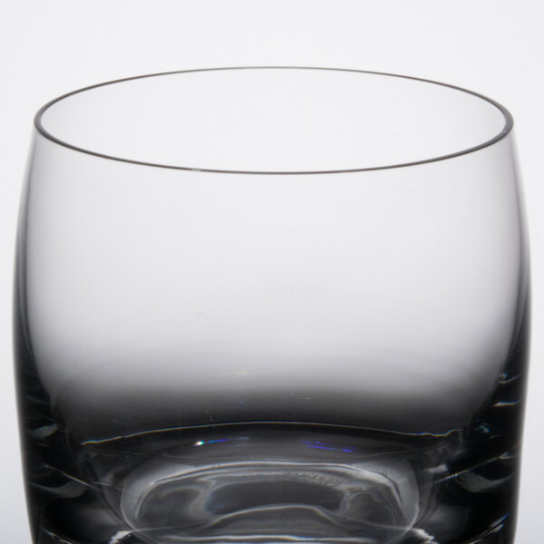 A close up of a Libbey Symmetry Rocks glass with a black rim.