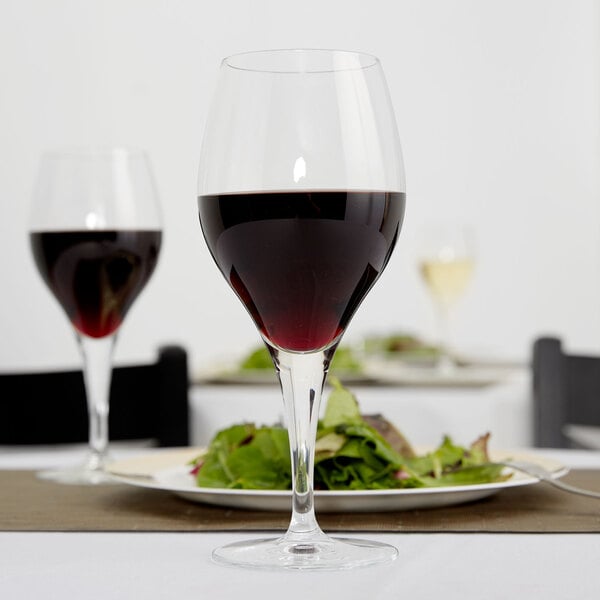 A Reserve by Libbey wine glass filled with red wine on a table.