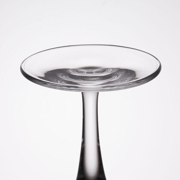 A close up of a clear Libbey wine glass with a round bottom and a clear rim.