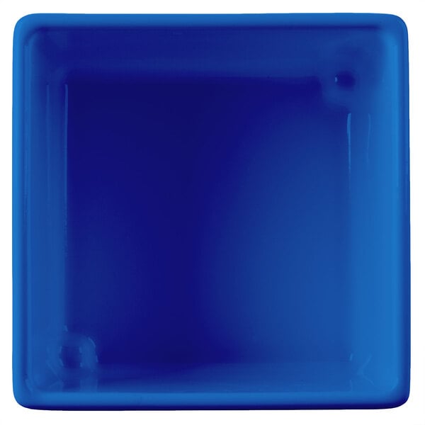 A cobalt blue square bowl with a white interior and straight sides.
