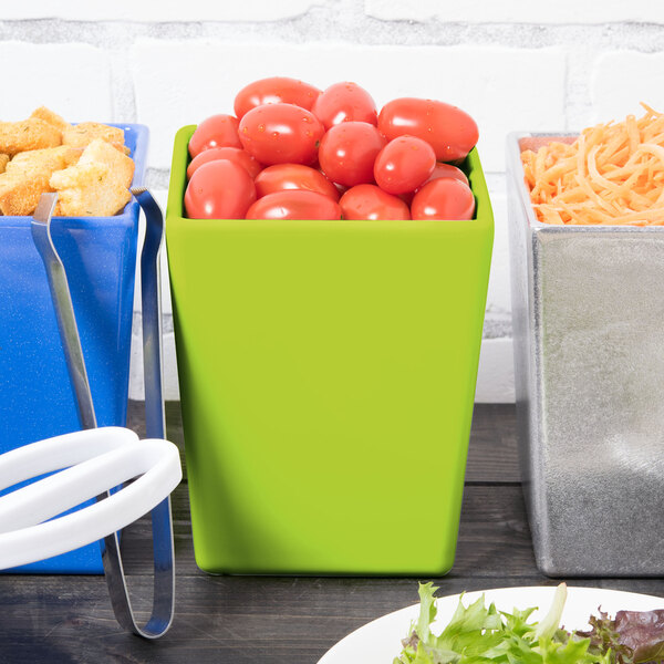 A Tablecraft lime green bowl on a table with tomatoes.