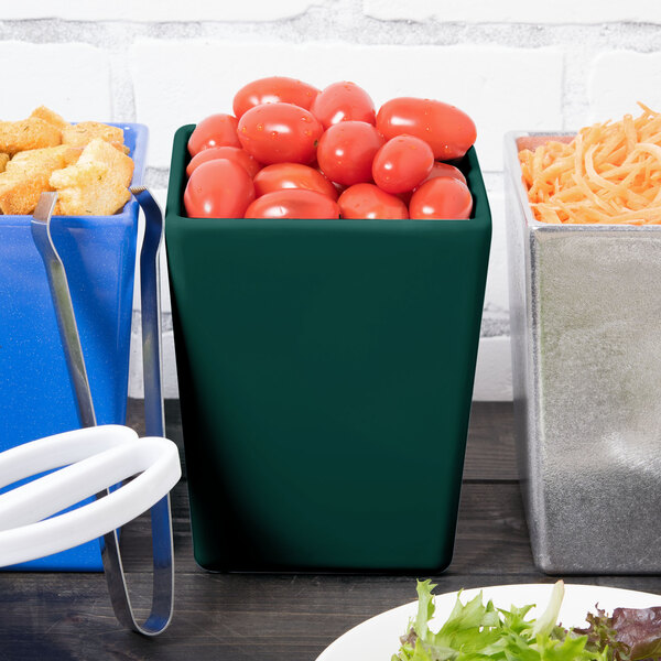 A Tablecraft hunter green bowl filled with tomatoes on a table in a salad bar.