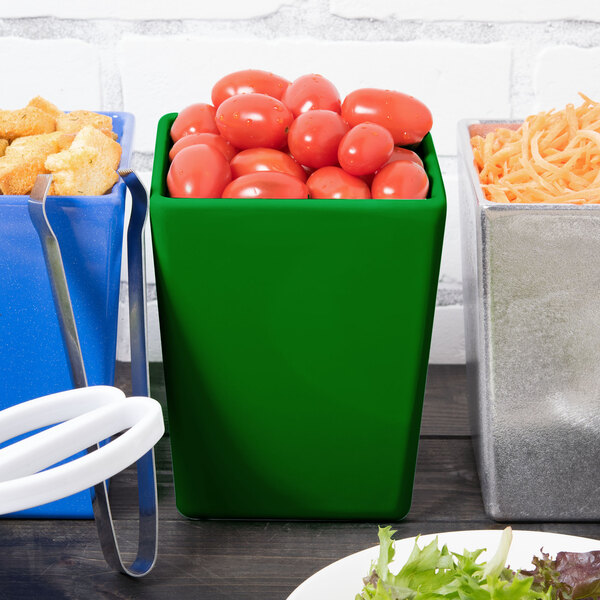 A green Tablecraft Contemporary Collection straight sided bowl full of tomatoes on a table in a salad bar.