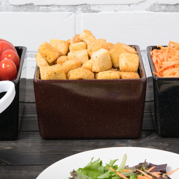 A maroon speckled Tablecraft bowl of food on a table in a salad bar.