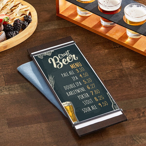 A dark wood Choice menu holder on a table with a beer glass and coaster.