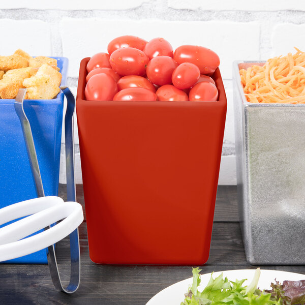 A Tablecraft copper bowl full of tomatoes on a table with other containers of food.