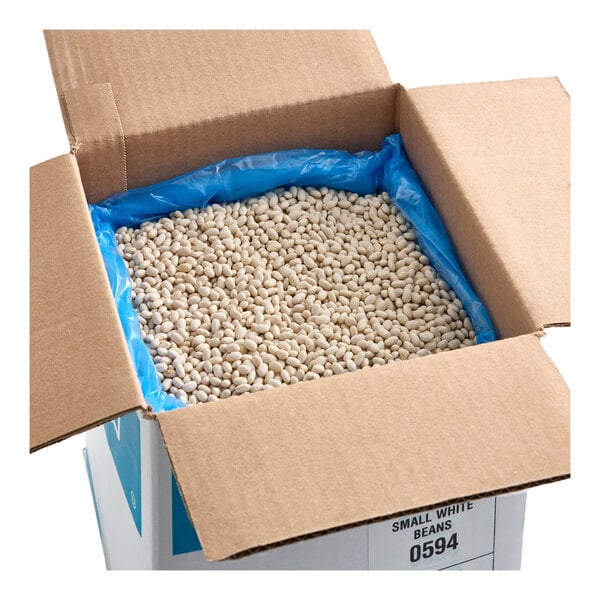 A large open cardboard box filled with dried small white beans lined with a blue plastic bag.