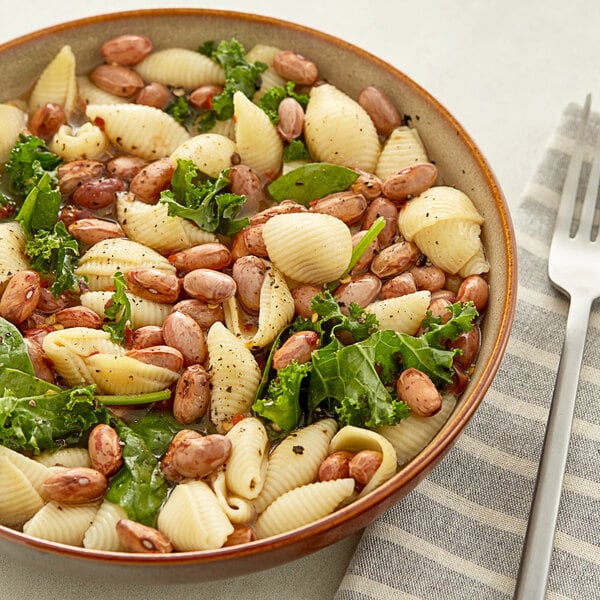 A bowl of pasta with cranberry beans and kale.