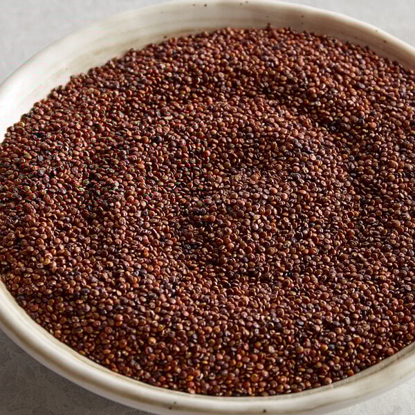 A bowl of brown organic red quinoa on a table.