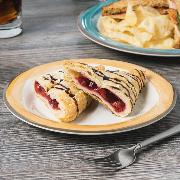 A Kanello Diamond Ivory melamine plate with pastries and a fork on it.