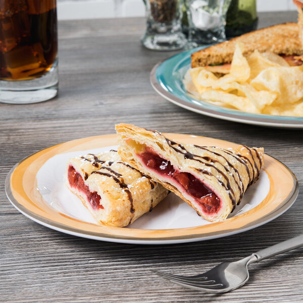 A Kanello white melamine plate with a sandwich, chips, and a glass of soda on it.