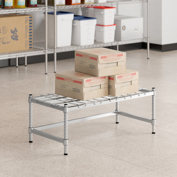 A group of boxes on a metal shelf with a Regency dunnage rack mat.