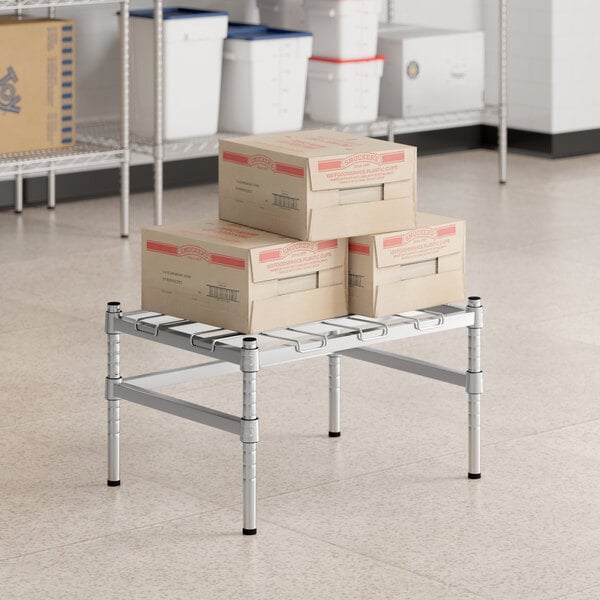 A metal shelf with a Regency chrome dunnage rack and boxes on it.