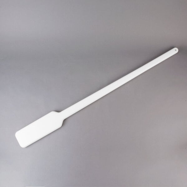 A white paddle on a gray surface.