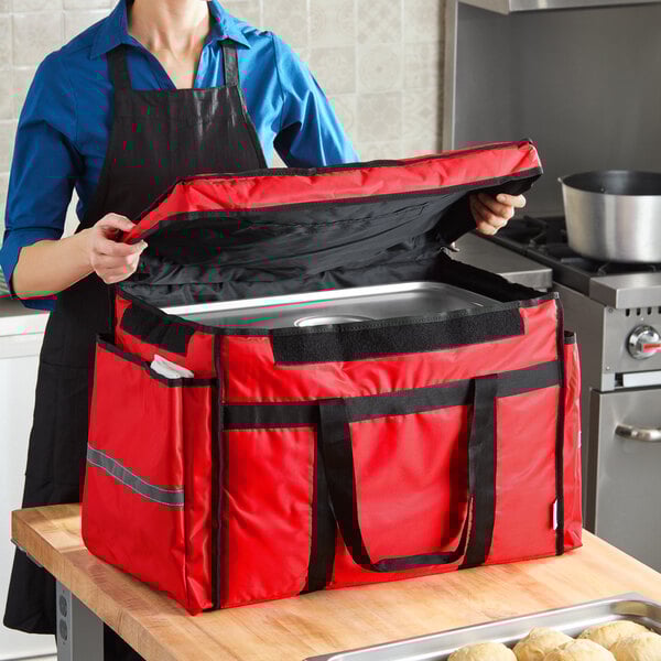 A red heavy-duty insulated soft-sided food delivery bag designed to hold six 2 1/2-inch deep full size food pans.