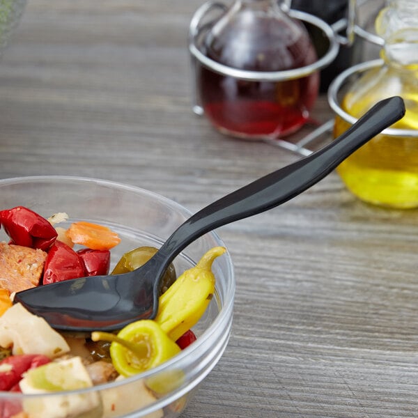 A bowl of food with a black plastic serving spoon in it.