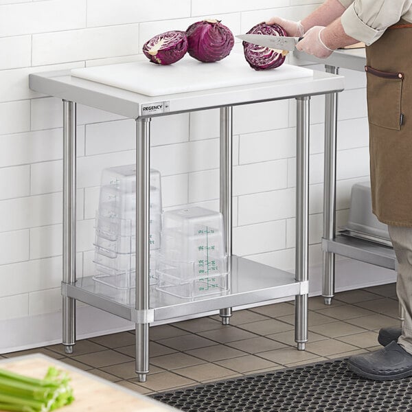 A man cutting a red cabbage on a Regency stainless steel work table with undershelf.