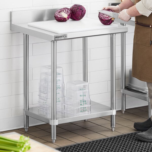 A man cutting red cabbage on a Regency stainless steel work table with undershelf.