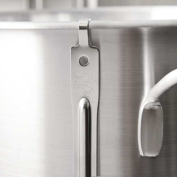 A Vollrath stainless steel pot fork with a hooked handle.