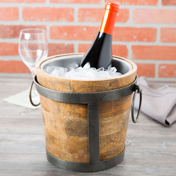 A 10 Strawberry Street Telluride natural wood wine bucket with a bottle of wine in ice.