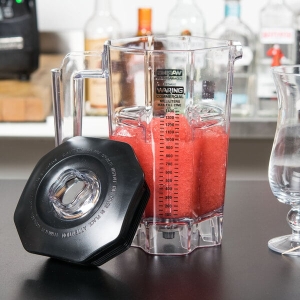 A Waring blender with red liquid in a clear plastic jar.