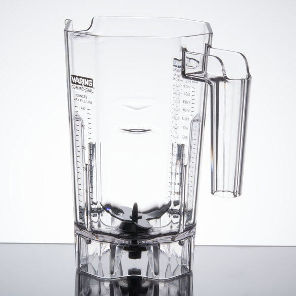 A clear plastic container with a handle for a Waring commercial blender.
